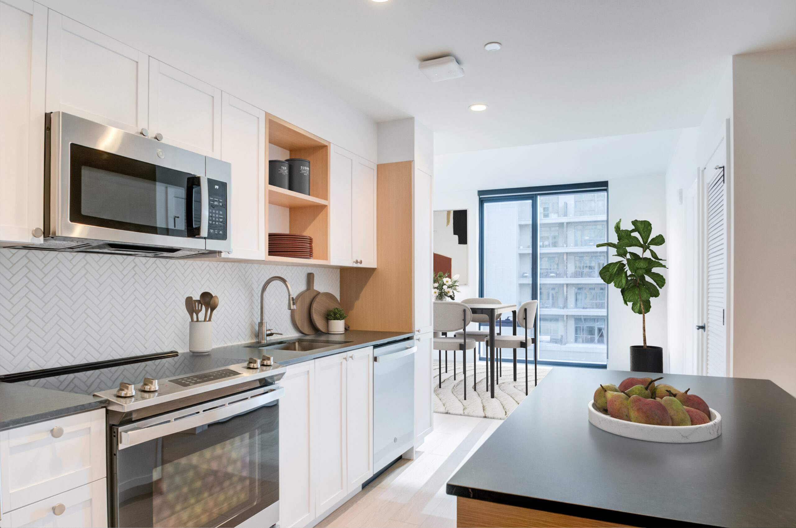 Kitchen with plank flooring, island, stylish cabinetry and backsplash.