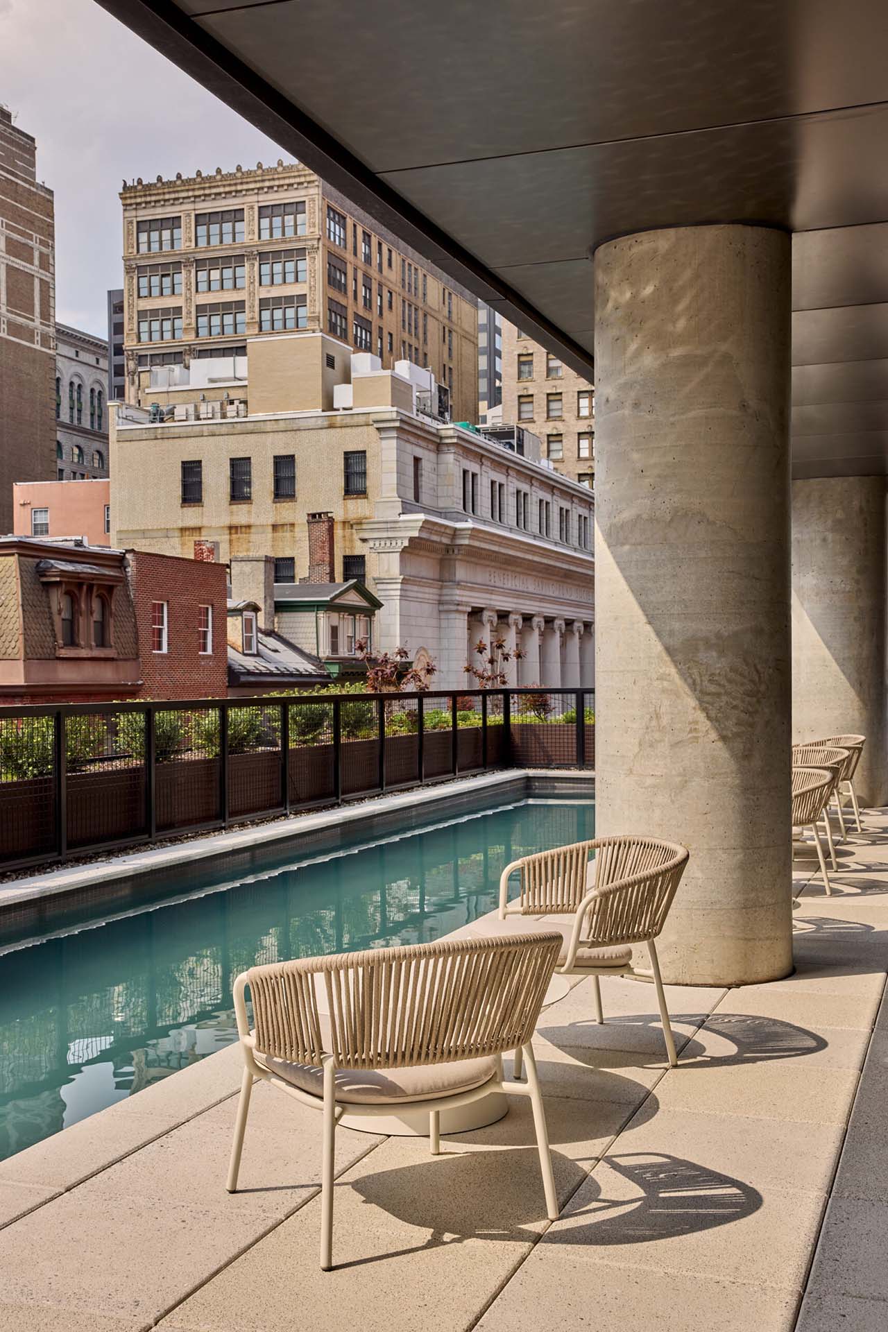 The pool area at Jessup House Apartments in Philadelphia, featuring outdoor chairs and a view of the nearby buildings.