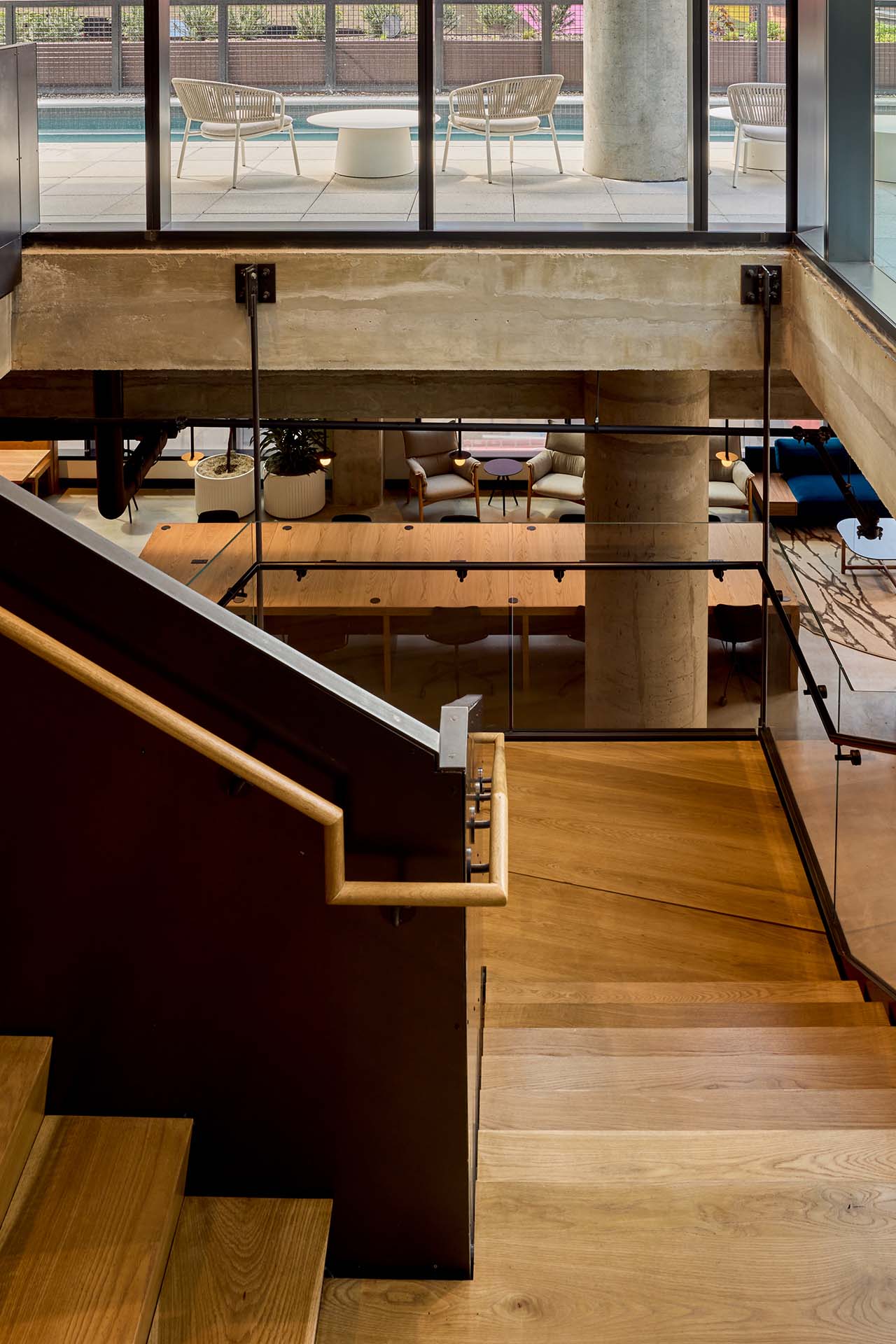 The stairway at Jessup House Apartments in Philadelphia, featuring wood grain flooring and a view of the lounge.